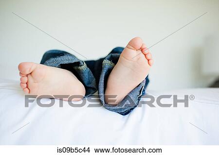 View of male toddler's bare feet, lying on bed View Large Photo Image Picture - View of male toddler's bare feet, lying on bed. Fotosearch