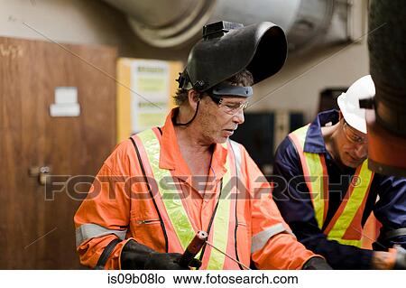 Welder and engineer in brainstorming session on oil rig View Large Photo Image Picture - Welder and engineer in brainstorming session on oil rig. Fotosearch