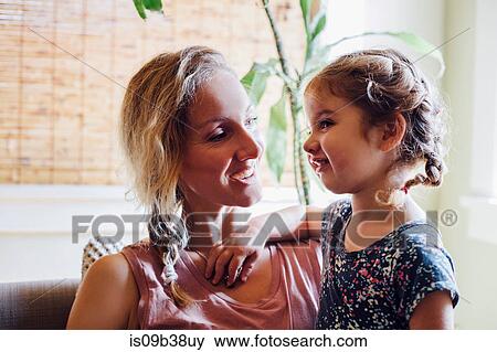 Stock Photo - Woman and toddler daughter relaxing on sofa. Fotosearch