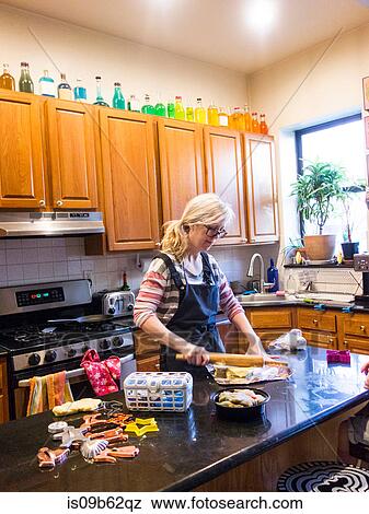 Stock Photo - Woman baking at kitchen counter. Fotosearch