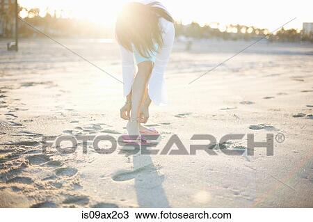 Woman bending to fasten anklet on Santa Monica beach, Cresent City, California, USA View Large Photo Image Stock Image - Woman bending to fasten anklet on Santa Monica beach, Cresent City, California, USA. Fotosearch