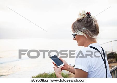 Woman by ocean holding smartphone, Encinitas, California, USA View Large Photo Image Stock Photo - Woman by ocean holding smartphone, Encinitas, California, USA. Fotosearch