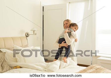Woman carrying tired toddler son in bedroom View Large Photo Image Picture - Woman carrying tired toddler son in bedroom. Fotosearch