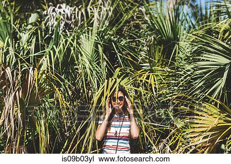 Woman hiding among palm fronds, Bonita Springs, Florida View Large Photo Image Stock Image - Woman hiding among palm fronds, Bonita Springs, Florida. Fotosearch