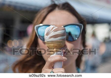 Woman holding ice cream cones in front of face, Coney island, Brooklyn, New York, USA View Large Photo Image Stock Photograph - Woman holding ice cream cones in front of face, Coney island, Brooklyn, New York, USA. Fotosearch