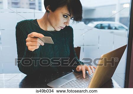 Woman in cafe making credit card payment on laptop View Large Photo Image Picture - Woman in cafe making credit card payment on laptop. Fotosearch