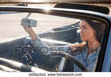 Woman in convertible car adjusting rear view mirror, Los Angeles, California, USA View Large Photo Image Stock Image - Woman in convertible car adjusting rear view mirror, Los Angeles, California, USA. Fotosearch