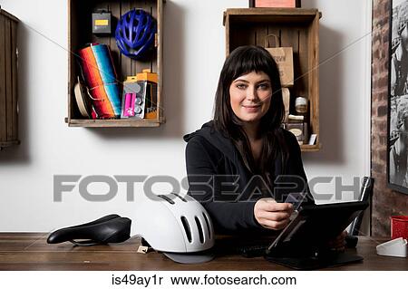 Stock Photography - Woman in cycling accessories shop. Fotosearch