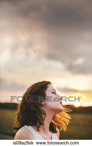 Stock Image - Woman in field looking away. Fotosearch