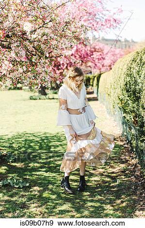 Woman in garden by cherry tree twirling dress View Large Photo Image Stock Photo - Woman in garden by cherry tree twirling dress. Fotosearch