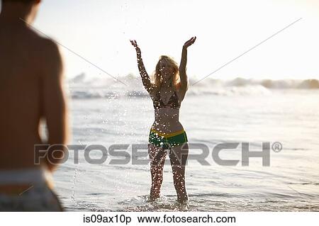 Woman in ocean wearing bikini arms raised splashing View Large Photo Image Stock Photography - Woman in ocean wearing bikini arms raised splashing. Fotosearch
