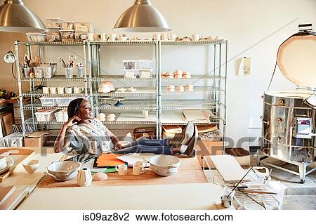 Woman in pottery workshop feet up looking away View Large Photo Image Stock Image - Woman in pottery workshop feet up looking away. Fotosearch
