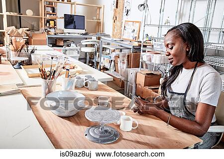 Woman in workshop painting pottery View Large Photo Image Stock Image - Woman in workshop painting pottery. Fotosearch