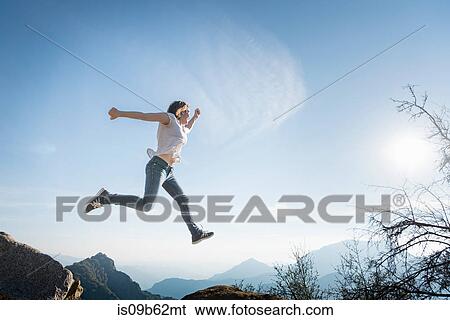 Woman jumping, blue sky in background, Sequoia National Park, California, US View Large Photo Image Stock Photograph - Woman jumping, blue sky in background, Sequoia National Park, California, US. Fotosearch