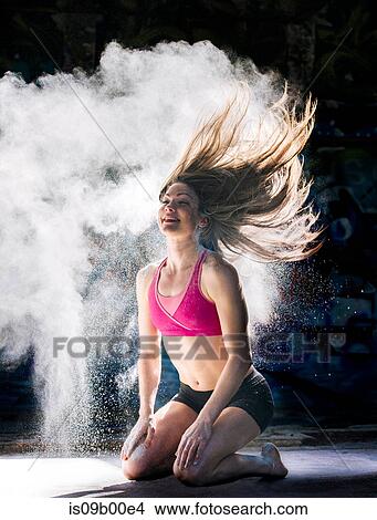 Woman kneeling throwing powder covered hair back smiling View Large Photo Image Picture - Woman kneeling throwing powder covered hair back smiling. Fotosearch