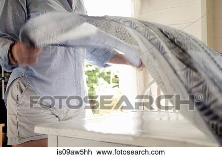 Woman laying cloth over table View Large Photo Image Stock Image - Woman laying cloth over table. Fotosearch