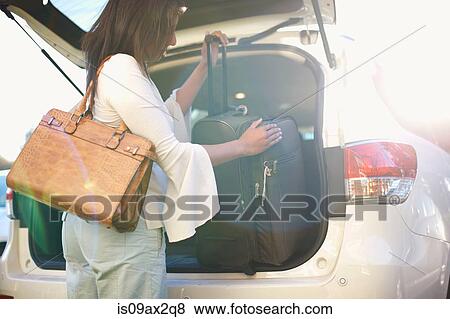 Woman loading luggage into boot of vehicle View Large Photo Image Stock Photo - Woman loading luggage into boot of vehicle. Fotosearch