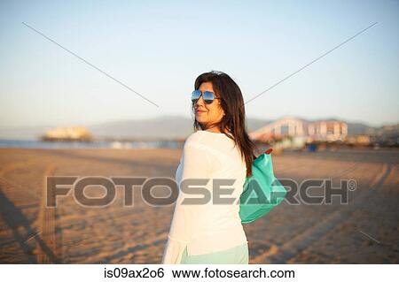 Woman looking back on Santa Monica beach at sunset, Cresent City, California, USA View Large Photo Image Stock Photograph - Woman looking back on Santa Monica beach at sunset, Cresent City, California, USA. Fotosearch