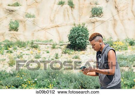 Woman looking down at smartphone View Large Photo Image Stock Image - Woman looking down at smartphone. Fotosearch
