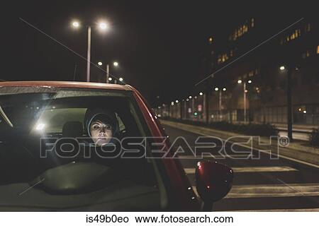 Woman looking out of car windscreen on city roadside at night View Large Photo Image Picture - Woman looking out of car windscreen on city roadside at night. Fotosearch