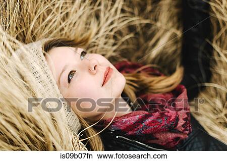 Woman lying in tall grass smiling View Large Photo Image Picture - Woman lying in tall grass smiling. Fotosearch