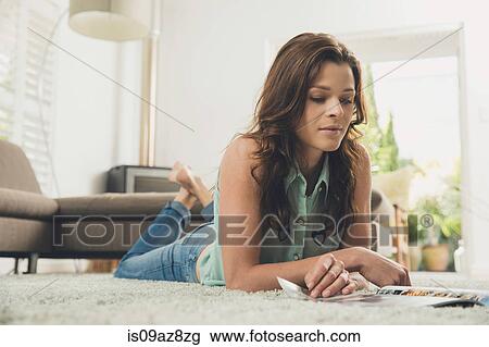 Woman lying on carpet reading magazine View Large Photo Image Stock Image - Woman lying on carpet reading magazine. Fotosearch