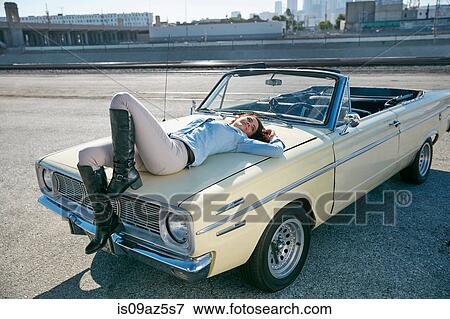 Woman lying on convertible car bonnet, Los Angeles, California, USA View Large Photo Image Stock Photo - Woman lying on convertible car bonnet, Los Angeles, California, USA. Fotosearch