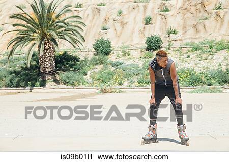 Woman on rollerblades, hands on knees looking away View Large Photo Image Stock Image - Woman on rollerblades, hands on knees looking away. Fotosearch