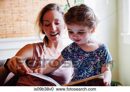 Woman on sofa with toddler daughter reading storybook View Large Photo Image Stock Image - Woman on sofa with toddler daughter reading storybook. Fotosearch