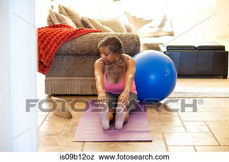 Woman on yoga mat using digital tablet, stretching View Large Photo Image Stock Photo - Woman on yoga mat using digital tablet, stretching. Fotosearch