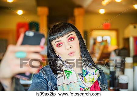 Woman pouting using smartphone to take selfie View Large Photo Image Stock Photography - Woman pouting using smartphone to take selfie. Fotosearch