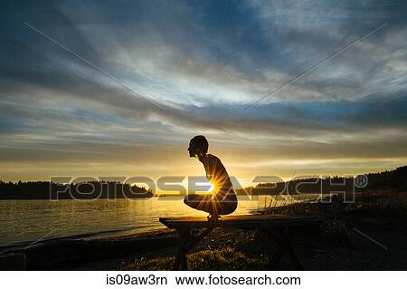 Woman practising yoga by lake at sunset View Large Photo Image Picture - Woman practising yoga by lake at sunset. Fotosearch