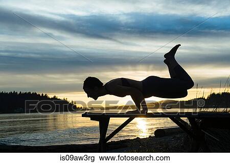 Woman practising yoga by lake at sunset View Large Photo Image Stock Image - Woman practising yoga by lake at sunset. Fotosearch