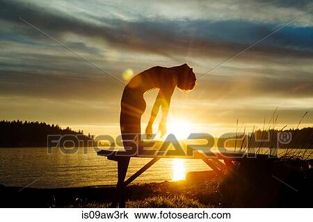 Woman practising yoga by lake at sunset View Large Photo Image Stock Image - Woman practising yoga by lake at sunset. Fotosearch