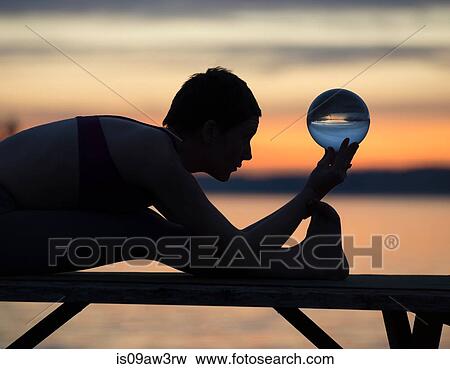 Woman practising yoga by lake at sunset View Large Photo Image Stock Photo - Woman practising yoga by lake at sunset. Fotosearch