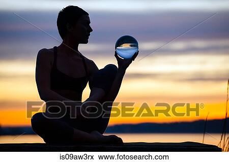 Woman practising yoga by lake at sunset View Large Photo Image Stock Photo - Woman practising yoga by lake at sunset. Fotosearch
