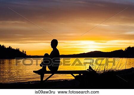 Woman practising yoga by lake at sunset View Large Photo Image Stock Photograph - Woman practising yoga by lake at sunset. Fotosearch