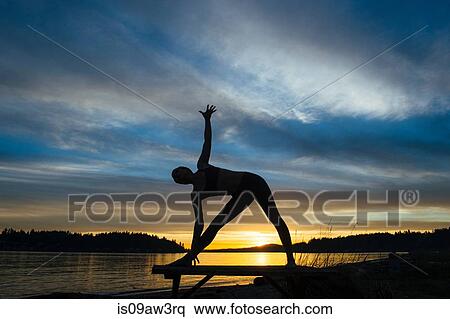 Woman practising yoga by lake at sunset View Large Photo Image Stock Photography - Woman practising yoga by lake at sunset. Fotosearch