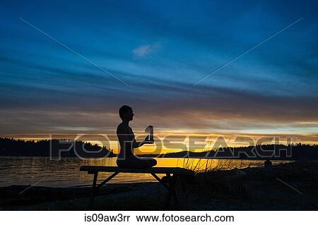 Woman practising yoga by lake at sunset View Large Photo Image Stock Photography - Woman practising yoga by lake at sunset. Fotosearch