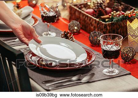 Stock Image - Woman preparing festive place setting. Fotosearch