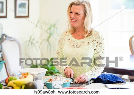 Woman preparing meal in kitchen View Large Photo Image Stock Image - Woman preparing meal in kitchen. Fotosearch