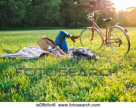 Woman reading book on grass View Large Photo Image Stock Photograph - Woman reading book on grass. Fotosearch