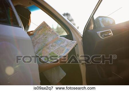 Stock Photo - Woman reading map inside vehicle. Fotosearch