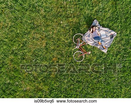 Woman relaxing on grass View Large Photo Image Stock Photograph - Woman relaxing on grass. Fotosearch