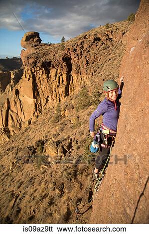 Woman rock climbing looking at camera smiling View Large Photo Image Stock Photograph - Woman rock climbing looking at camera smiling. Fotosearch