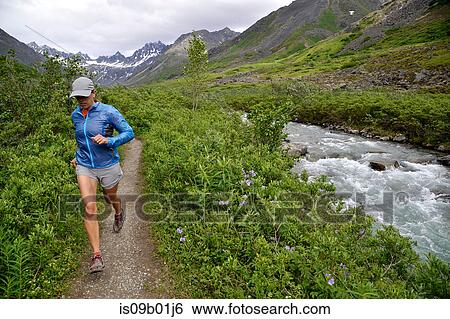Stock Photograph - Woman running the Gold Mint Trail by Little Susitna River, Talkeetna Mountains near Hatcher Pass, Alaska, USA. Fotosearch
