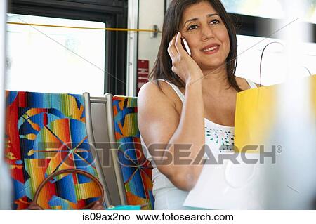 Woman sitting on bus chatting on smartphone, Los Angeles, California, USA View Large Photo Image Picture - Woman sitting on bus chatting on smartphone, Los Angeles, California, USA. Fotosearch