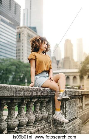 Woman sitting on stone baluster in front of Chicago skyline, Illinois View Large Photo Image Stock Image - Woman sitting on stone baluster in front of Chicago skyline, Illinois. Fotosearch