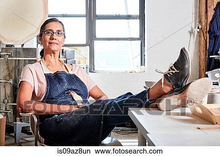 Woman sitting with feet up in pottery workshop View Large Photo Image Picture - Woman sitting with feet up in pottery workshop. Fotosearch