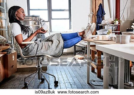 Woman sitting with feet up in pottery workshop View Large Photo Image Stock Image - Woman sitting with feet up in pottery workshop. Fotosearch